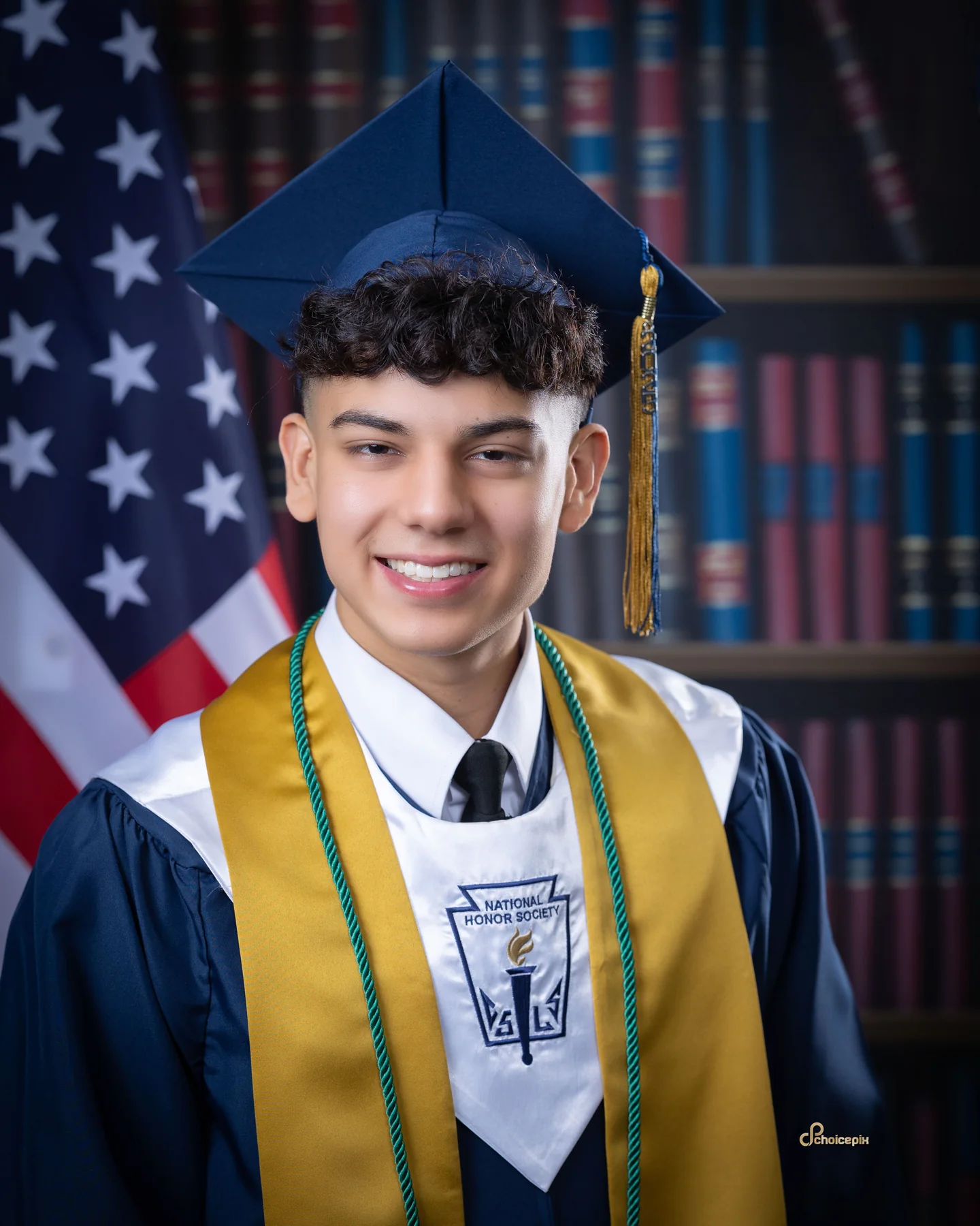 Senior in a navy cap and gown holding a diploma