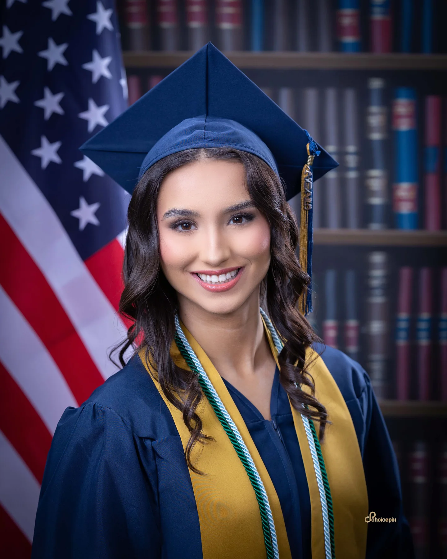 Senior in a navy cap and gown with gold stoles