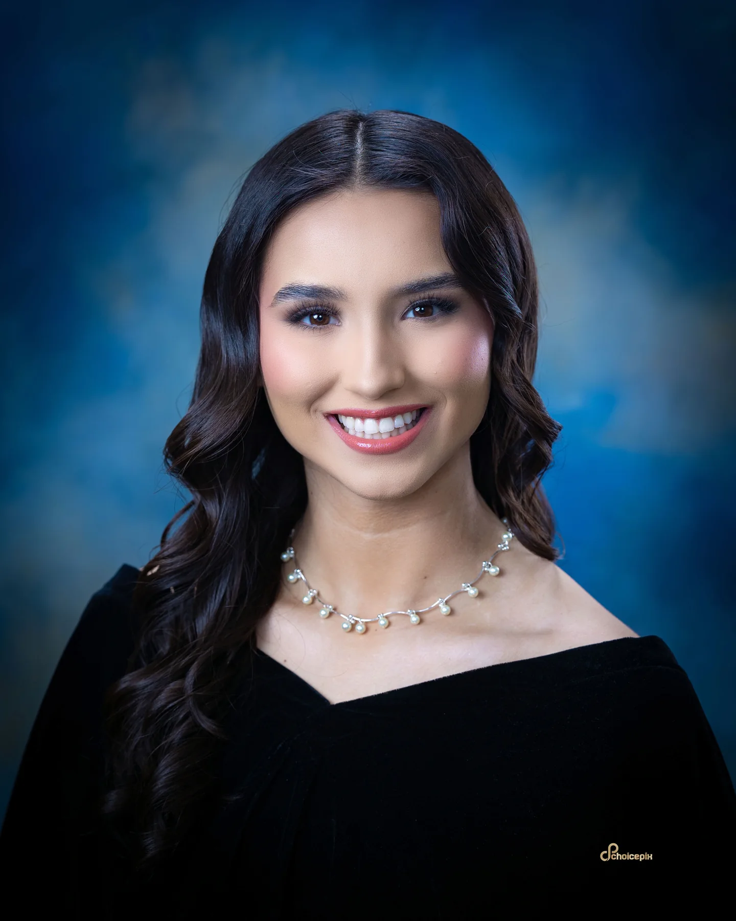 Formal senior portrait with a black drape and lace sleeves